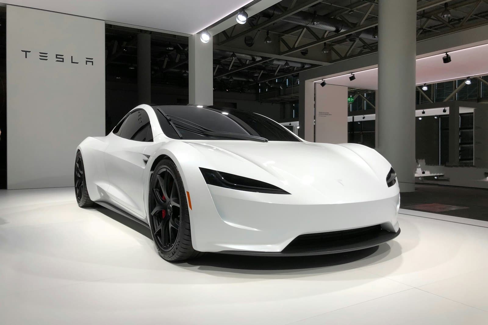 White Tesla Roadster displayed on a motor-show stand