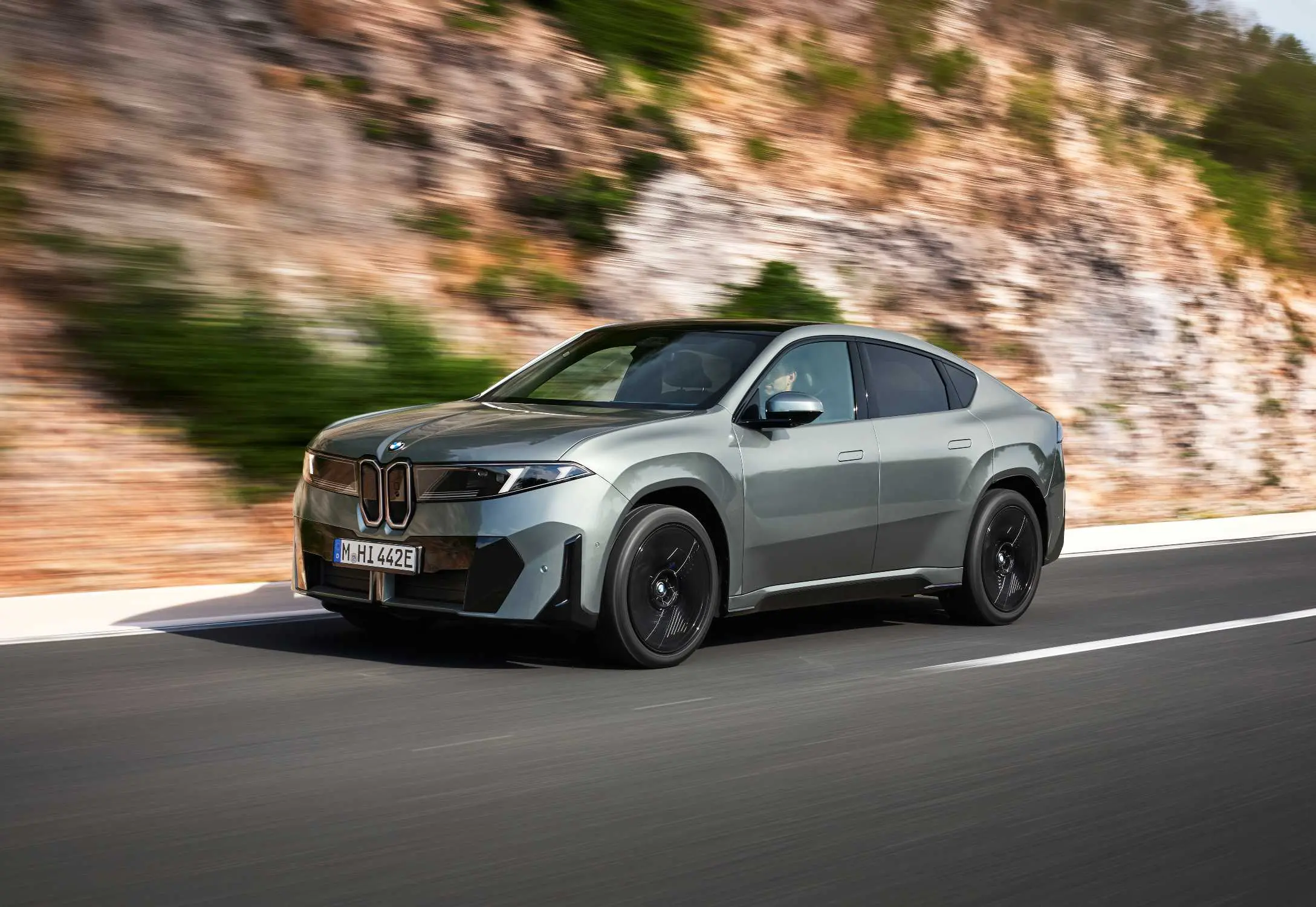 BMW iX4 50 xDrive viewed from the front on a road