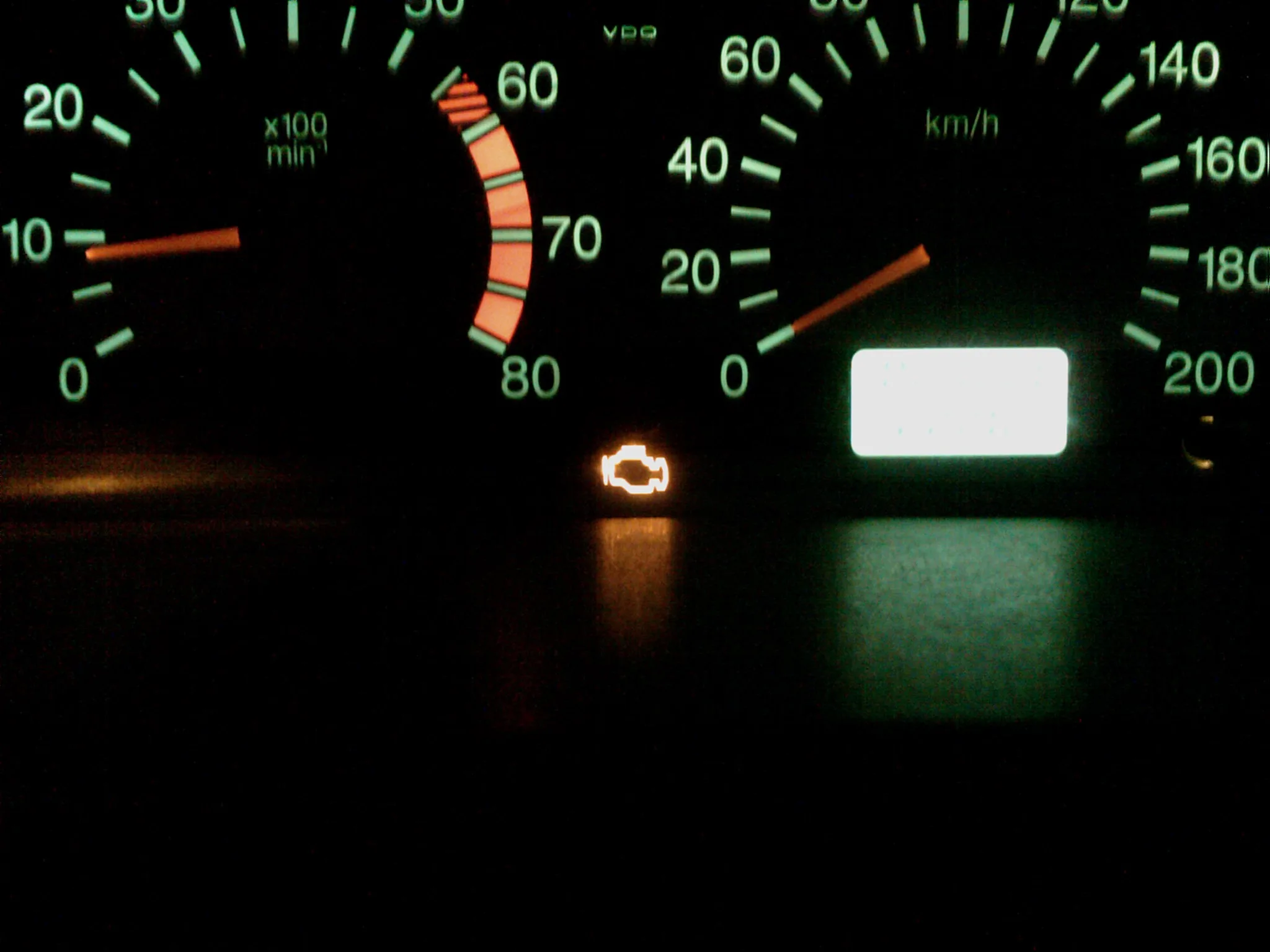 Amber check-engine warning light illuminated on a car dashboard