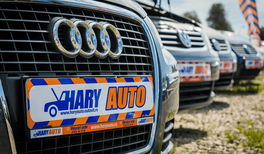 Used cars on the Hary Auto lot, with the dealer’s promotional plates