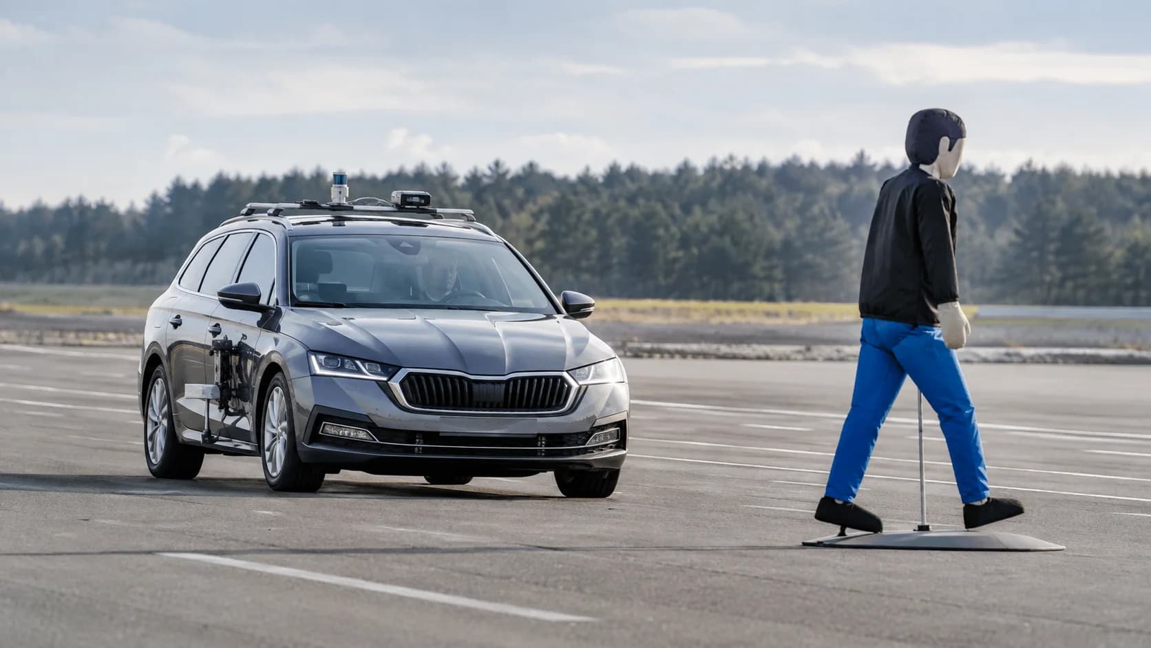 A Euro NCAP engineer prepares a car with sensors and cameras for a driver-assistance system test on a proving ground.
