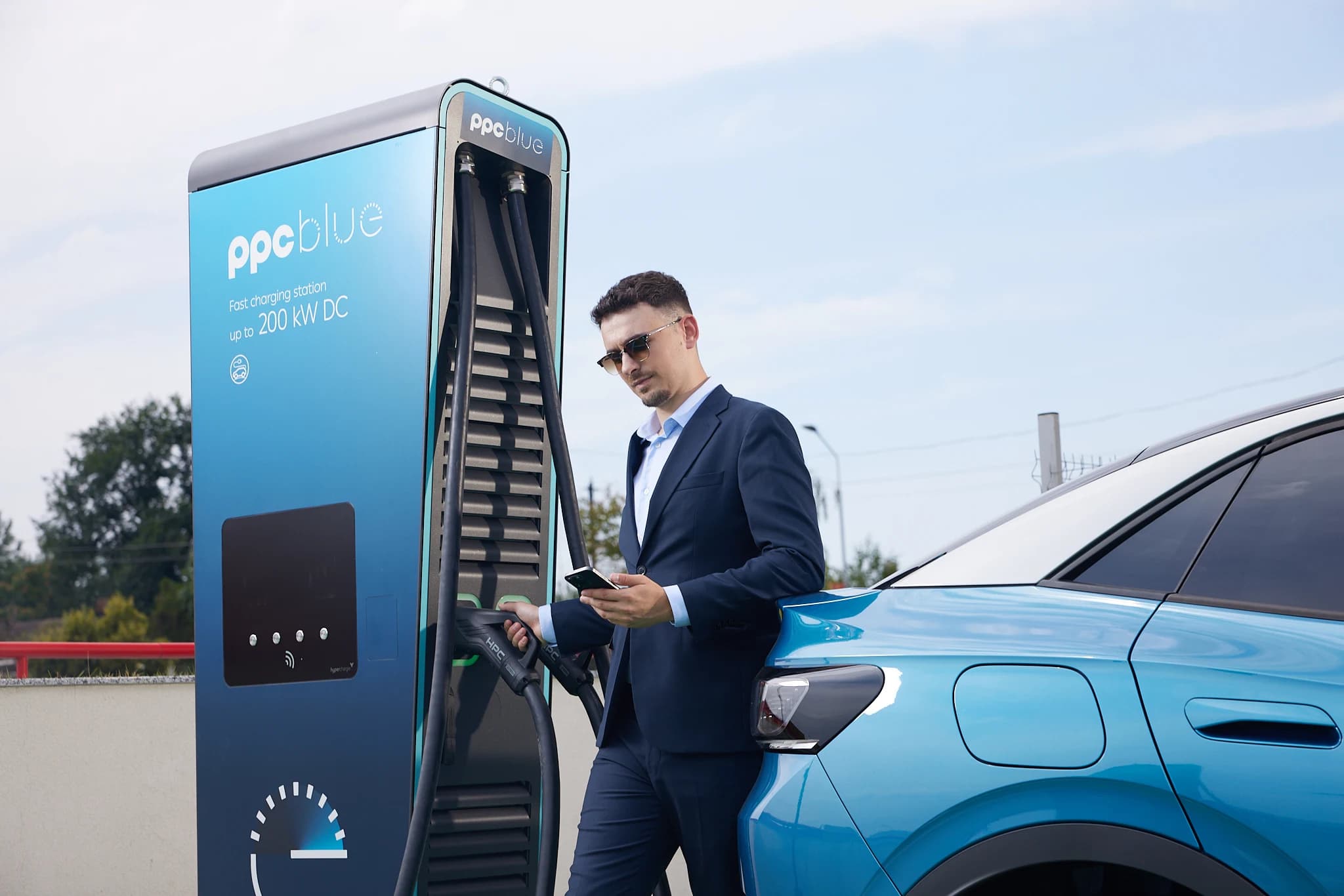 Estación de recarga rápida PPC blue junto a un coche eléctrico
