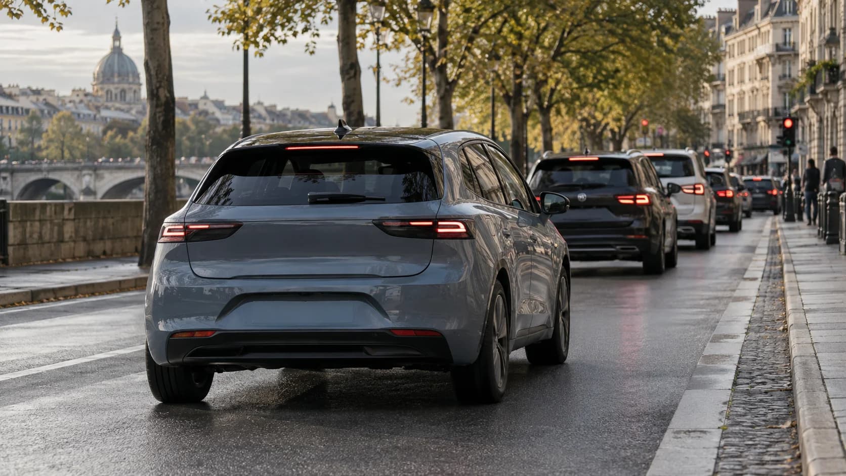 Un'auto elettrica o ibrida frena in città, con le luci dei freni accese, mentre recupera energia.