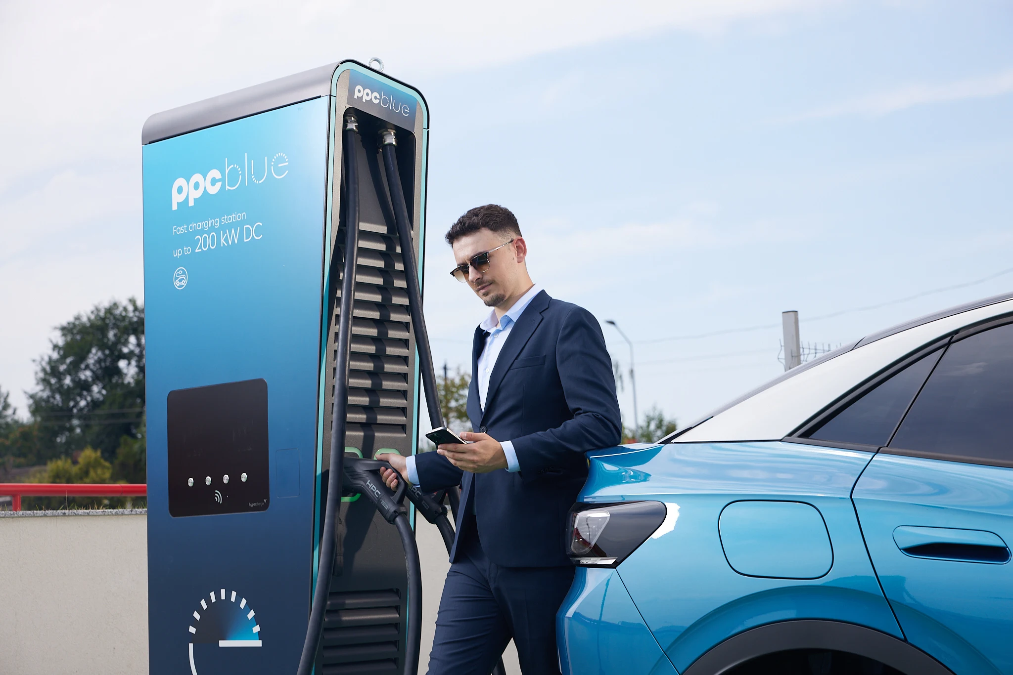 Estación de recarga rápida PPC blue junto a un coche eléctrico