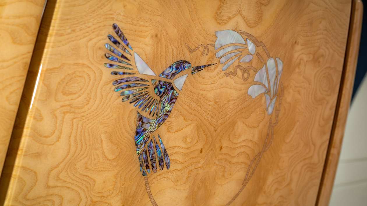Hummingbird made from fragments of abalone and mother-of-pearl on a wood panel